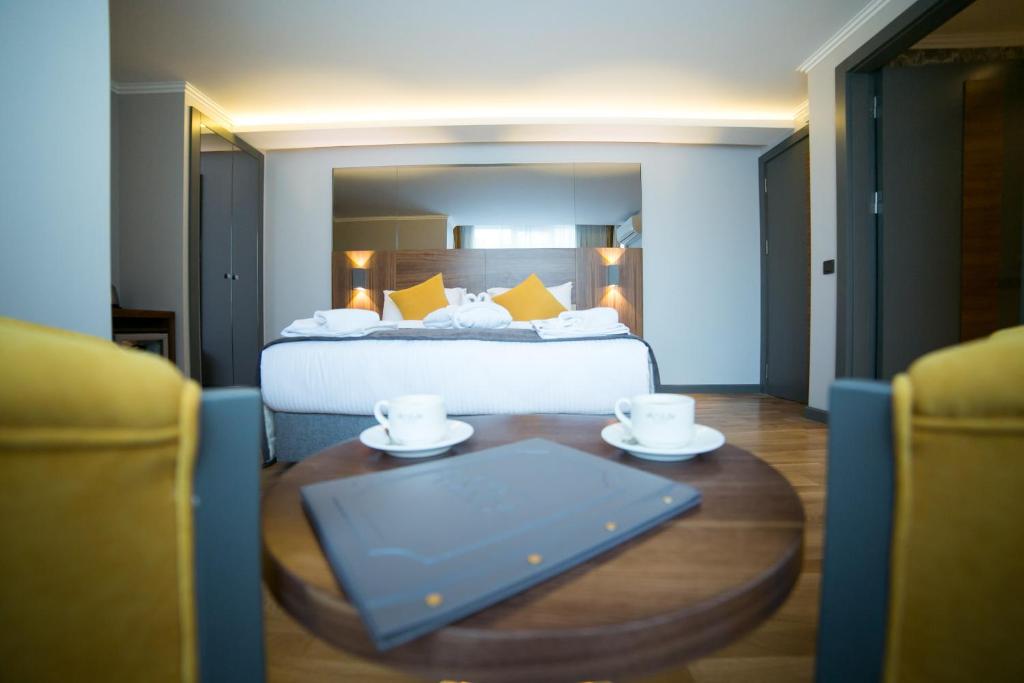a hotel room with a bed and a table with two cups at Ankacity Suit Flat in Ankara