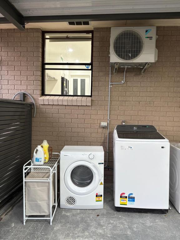 a washer and a washing machine sitting next to a wall at An enchating and enriching home in Fairfield