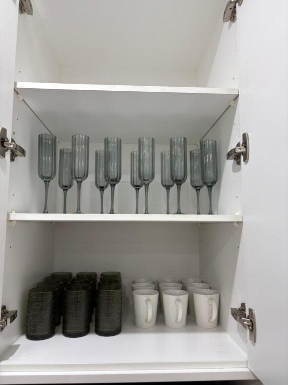 a shelf with a bunch of wine glasses at An enchating and enriching home in Fairfield