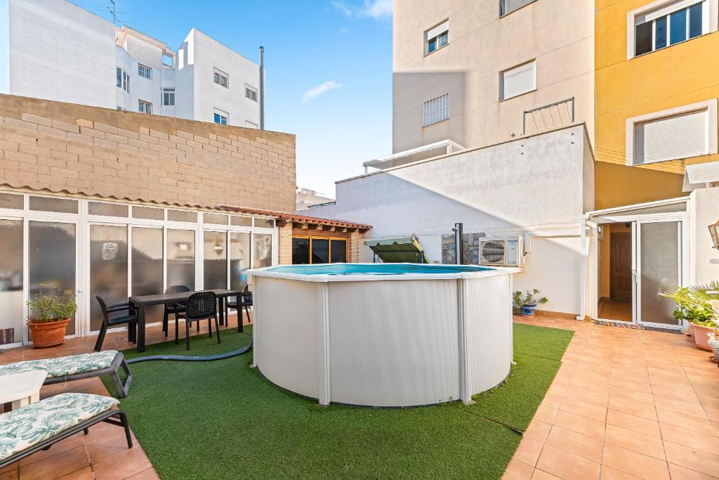 een achtertuin met een hot tub in het midden van een gebouw bij Yovalutres Piscina Privada Torrevi in Torrevieja