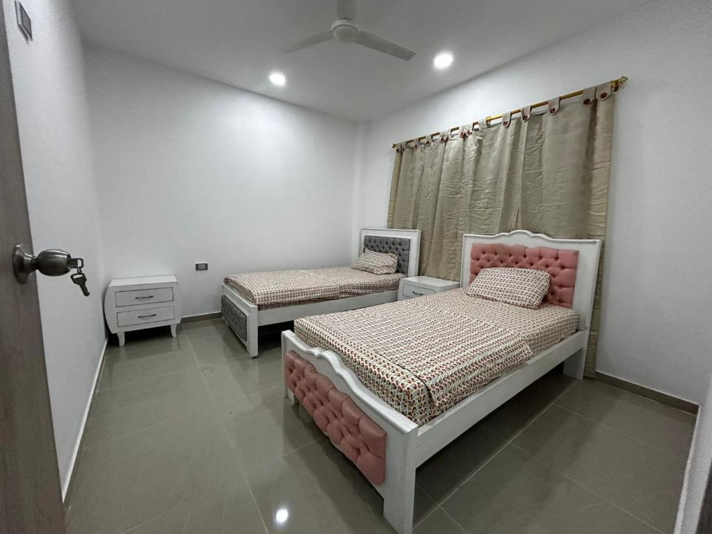 a bedroom with two beds and a window at Apartamento Aracataca in Aracataca