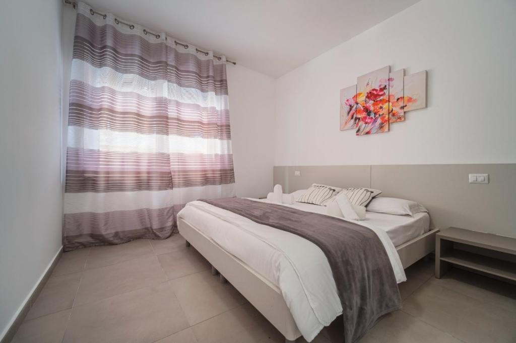 タオルミーナにあるFlower Taormina Apartmentのベッドと窓のある白い寝室