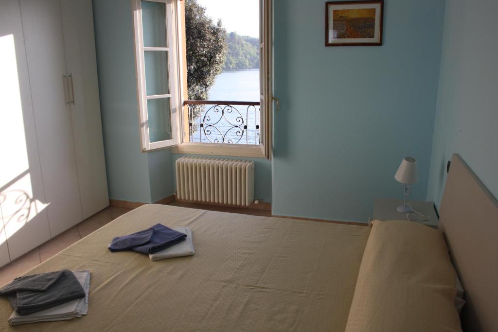 a room with a bed and a window with towels on it at Appartamento De Angeli in Laveno-Mombello