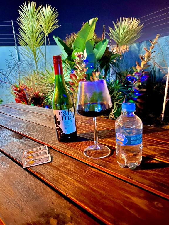 a bottle of wine and a glass of water on a wooden table at The Legacy BnB in East London