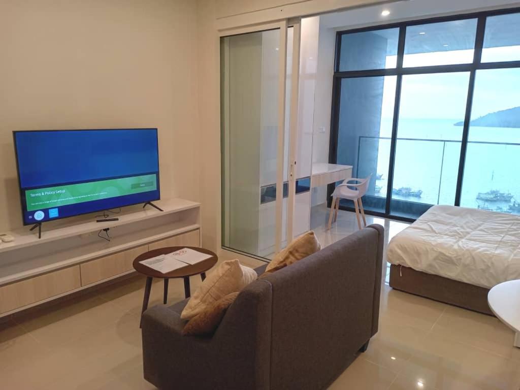 a living room with a couch and a tv and a bed at MC homes in Kota Kinabalu