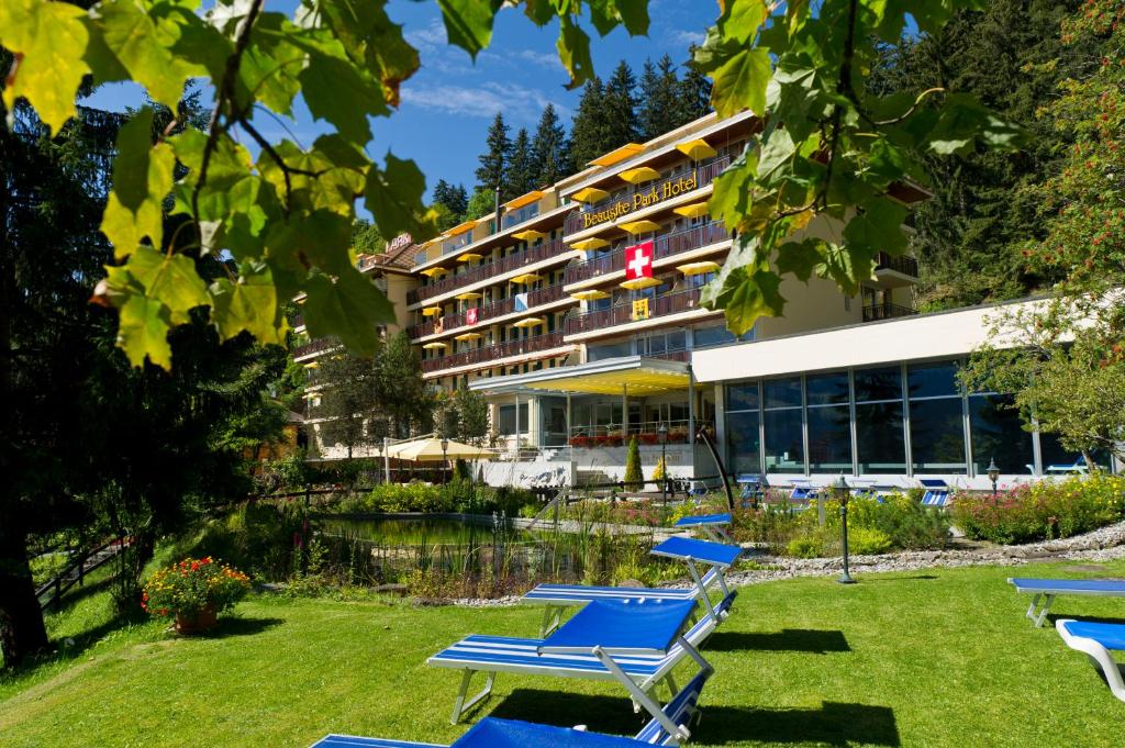 un hôtel avec des chaises longues devant un bâtiment dans l'établissement Beausite Park Hotel & Spa, à Wengen