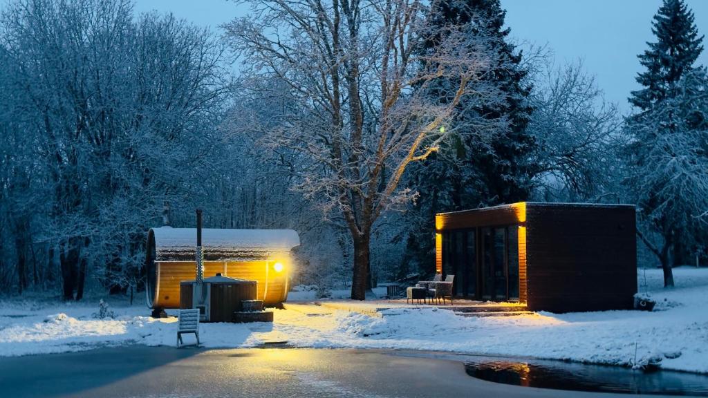 un piccolo edificio nella neve accanto a una strada di Puhkemaja metsa sees a Urvaste