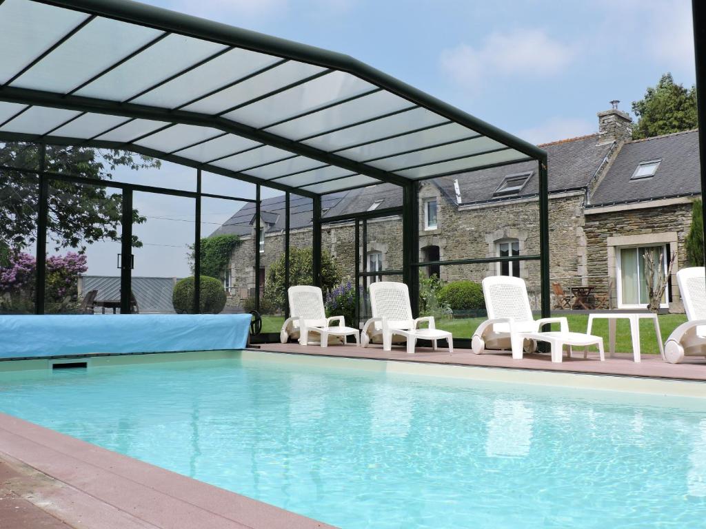 - un groupe de chaises blanches et une piscine dans l'établissement Chambres d'hôtes - Au Domaine des Camélias, à Pluméliau