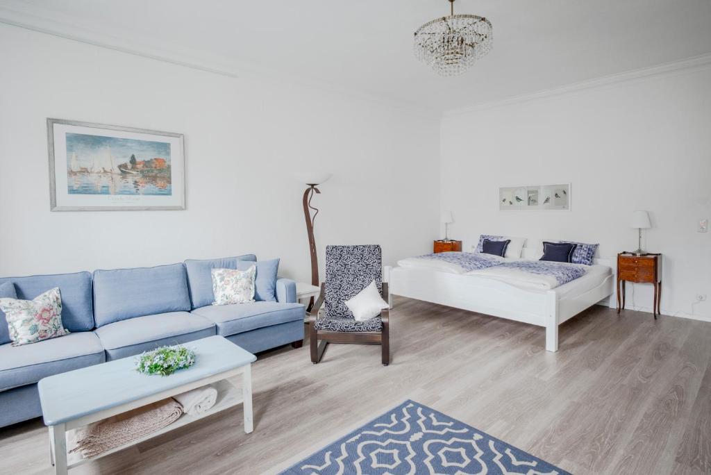 ein Wohnzimmer mit einem blauen Sofa und einem Tisch in der Unterkunft Ferienwohnung Stadtplatz 25 in Traunstein