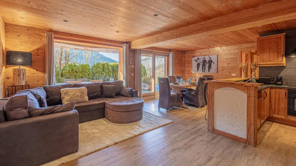 un salon avec un canapé et une grande fenêtre dans l'établissement Le Refuge Alpin, au Grand-Bornand