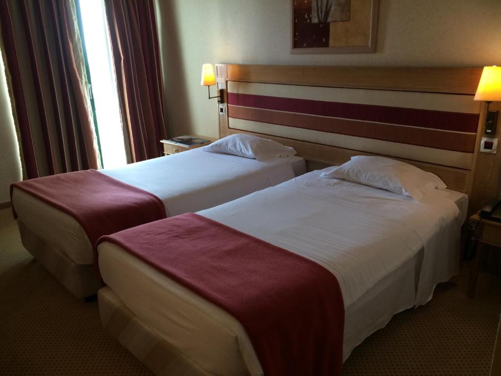 a hotel room with two beds in a room at Riviera Hotel in Carcavelos