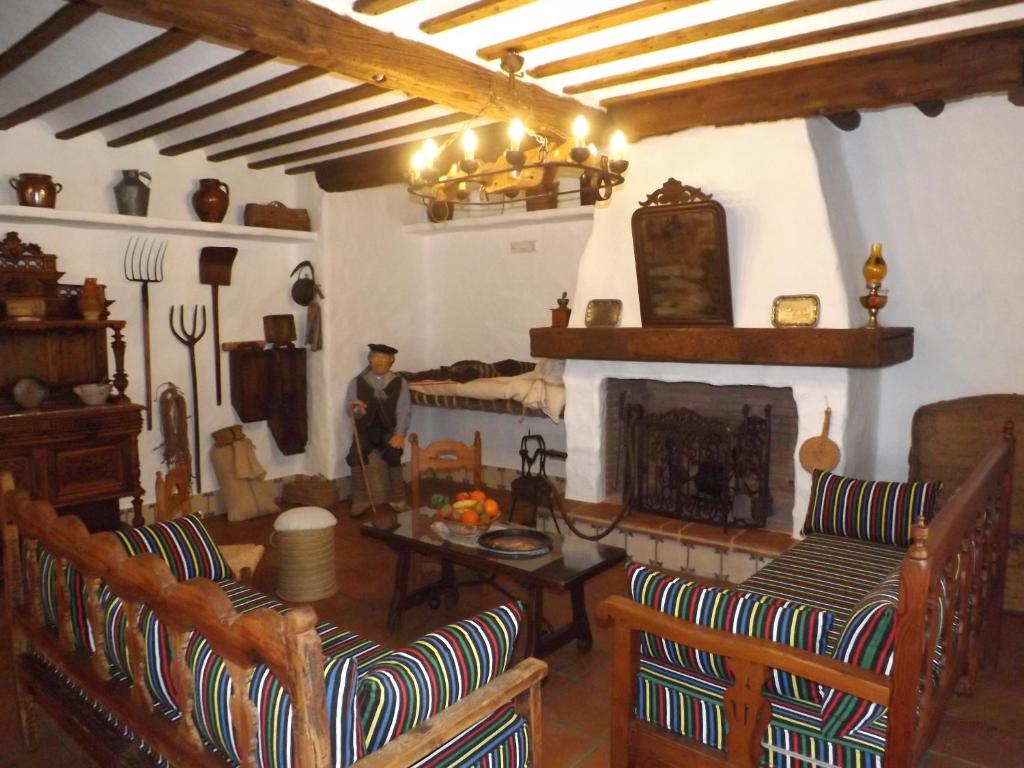 a living room with chairs and a fireplace at Casa Rural El Arriero in Los Hinojosos
