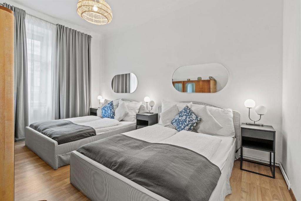ein Schlafzimmer mit zwei Betten und einem Spiegel in der Unterkunft Spacious 2 Bedroom I 2 Minutes to Metro and Train Station in Wien