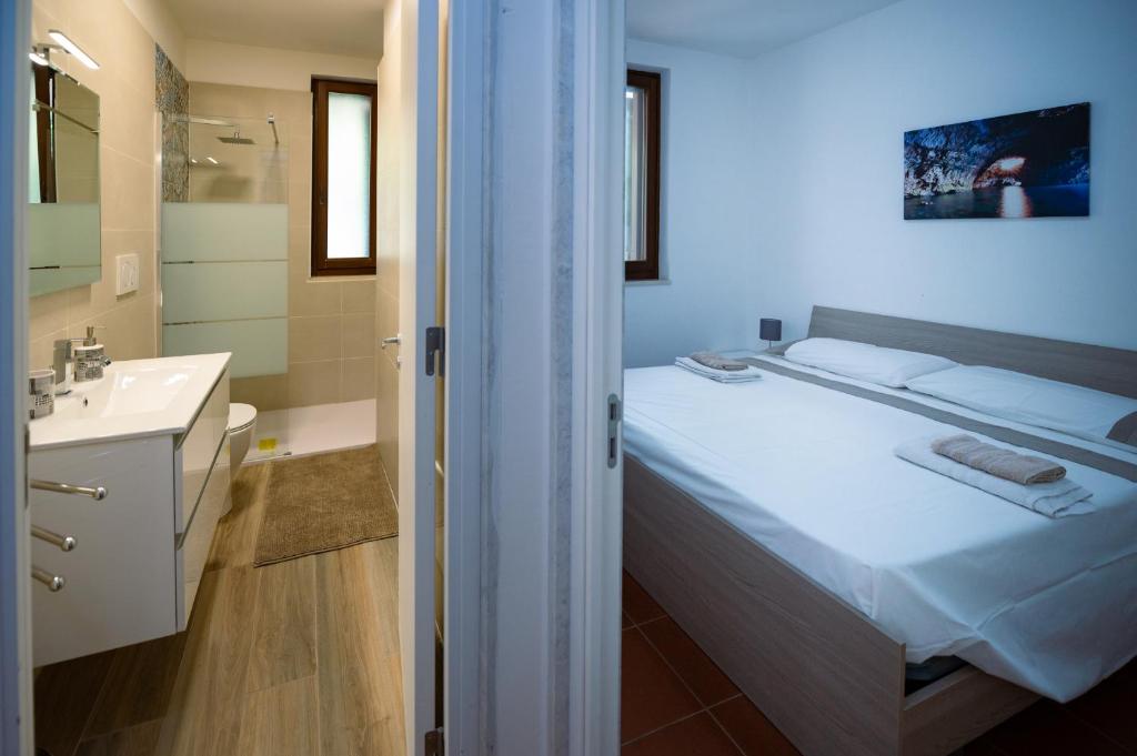 a bedroom with a bed and a bathroom with a sink at Villa Gianto pool & spa in Polignano a Mare