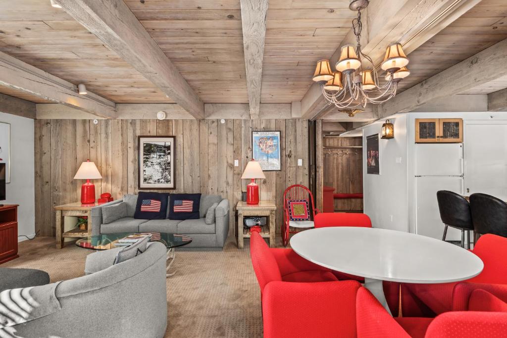 un soggiorno con sedie rosse e un tavolo di Chateau Eau Claire Unit 1, Stylish Condo Overlooking the River, Walking Distance to Downtown ad Aspen