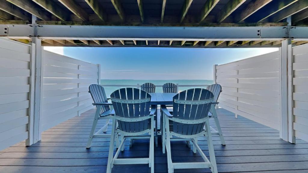a table and chairs on a deck with the ocean at Put-in-Bay Waterfront Condo #107 in Put-in-Bay