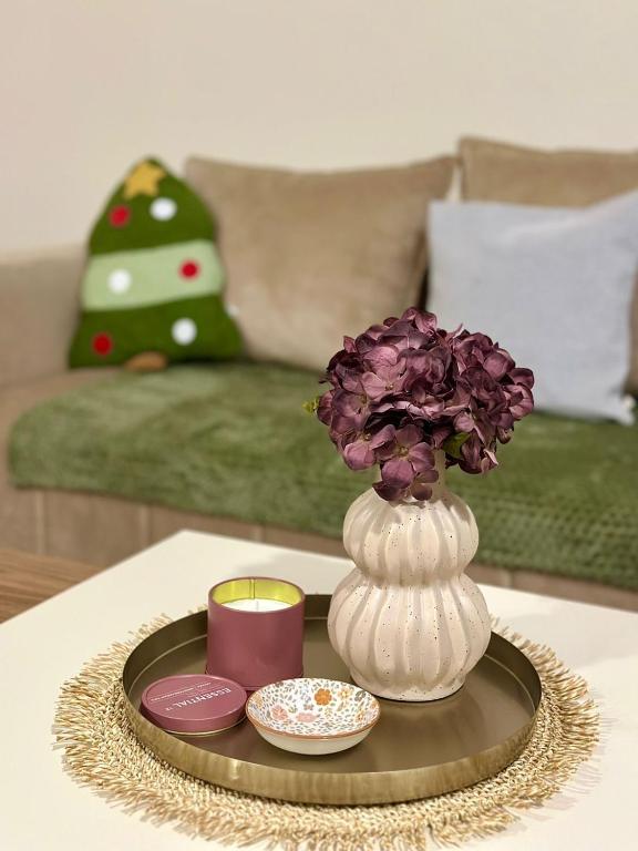 a tray with a vase and a candle on a table at Pine forest view apartment in Kolašin