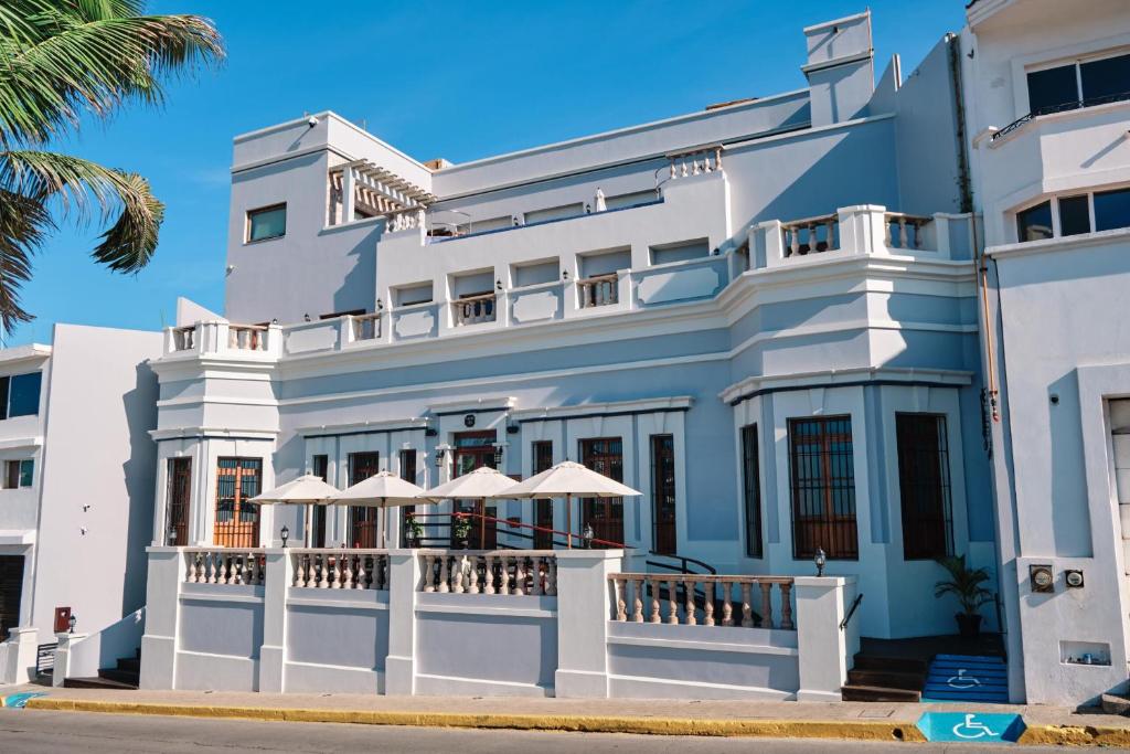 a large white building with umbrellas in front of it at Casa Lucila Mazatlán Curamoria Collection in Mazatlán