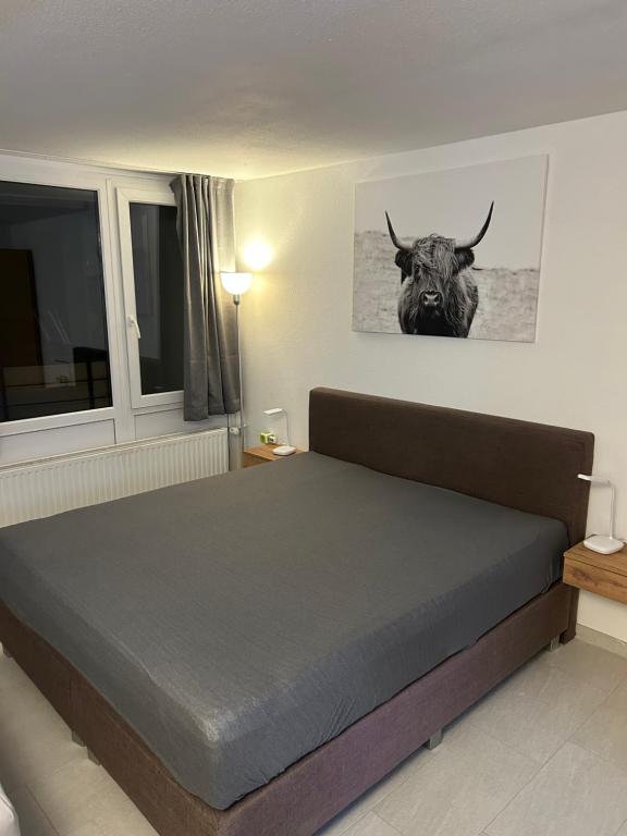 una camera da letto con un letto con un toro sul muro di FeWo Jule im Predigtstuhl Resort a Sankt Englmar