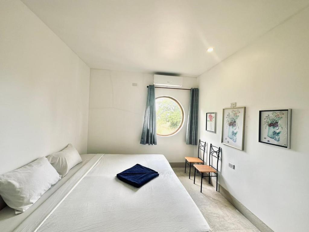 a white bedroom with a bed and a window at Kohchang stayin premium hotel in beach street market in Ko Chang