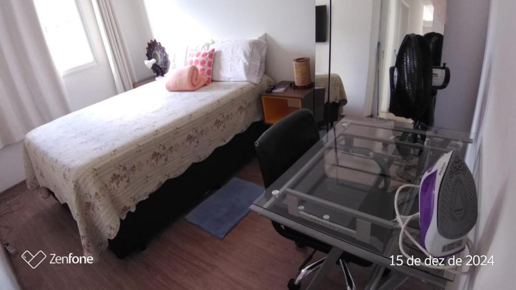 a bedroom with a bed with a chair and a desk at Apartamento no portal dos ipes cajamar in Cajamar