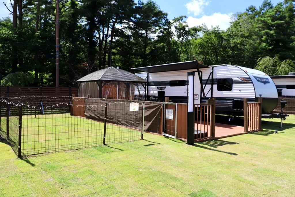 an rv parked next to a gazebo and a fence at Gramercy Village Lake Yamanaka Glamping & Sauna - Vacation STAY 92838v in Yamanakako
