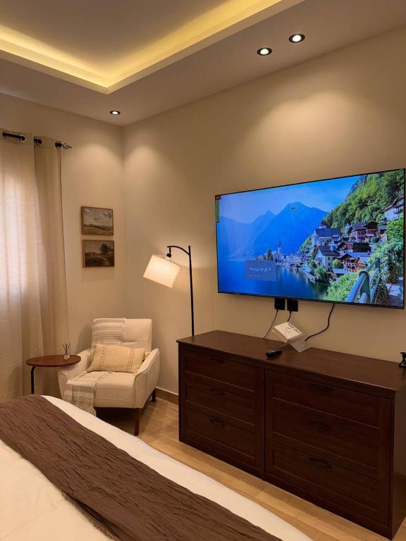 een slaapkamer met een grote flatscreen-tv aan de muur bij غرفة على الطراز الريفي in Riyad