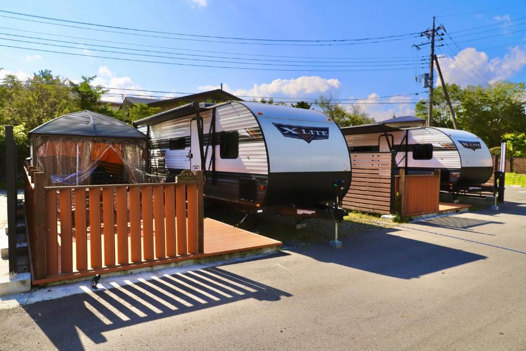 a couple of recreational vehicles parked in a parking lot at Gramercy Village Lake Yamanaka Glamping & Sauna - Vacation STAY 92837v in Yamanakako