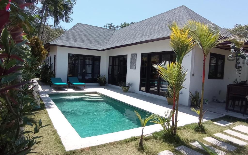 a swimming pool in front of a house at Villa Amber in Uluwatu