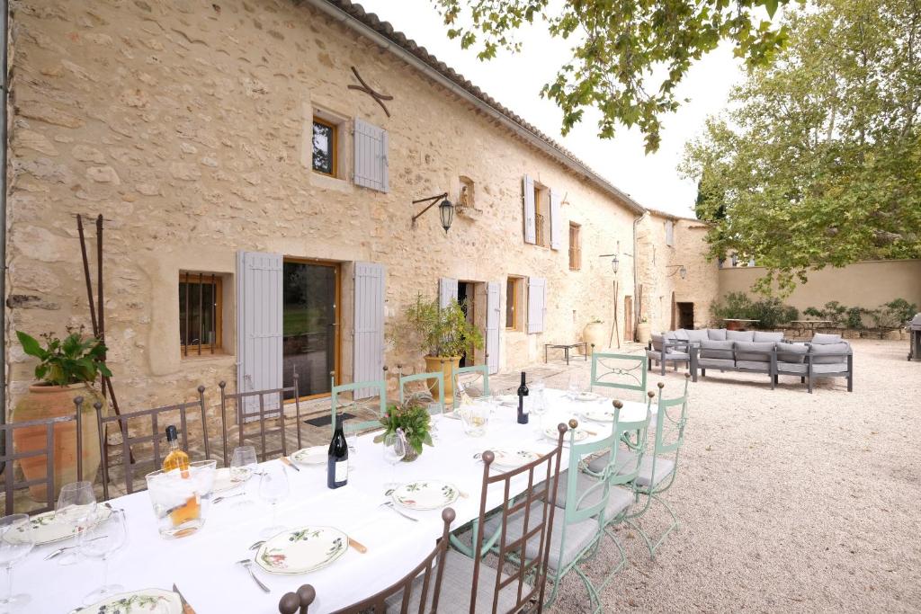 - une table pour un dîner en face d'un bâtiment dans l'établissement Authentique mas avec vue et piscine Eygalieres LS1-447, à Eygalières