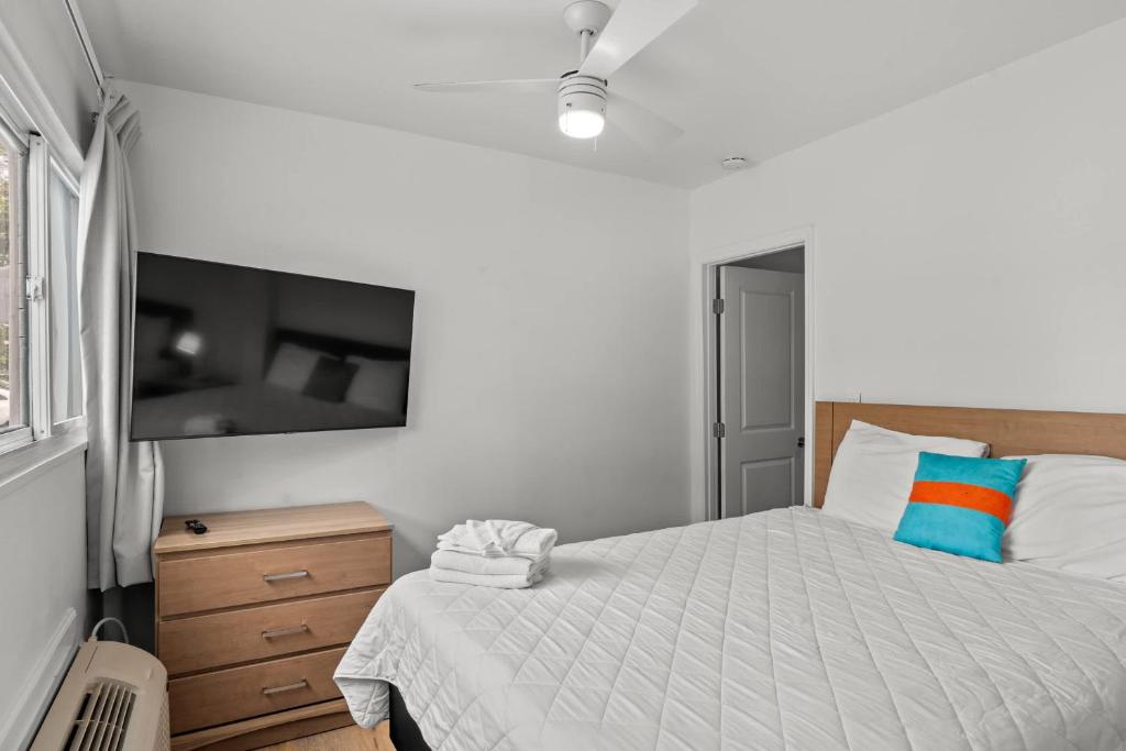 ein Schlafzimmer mit einem Bett und einem Flachbildfernseher in der Unterkunft 4BR2BA Sleeps 12 Pet-Friendly Steps to Beach in Myrtle Beach