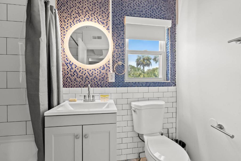 ein Badezimmer mit Toilette, Waschbecken und Spiegel in der Unterkunft 4BR2BA Sleeps 12 Pet-Friendly Steps to Beach in Myrtle Beach