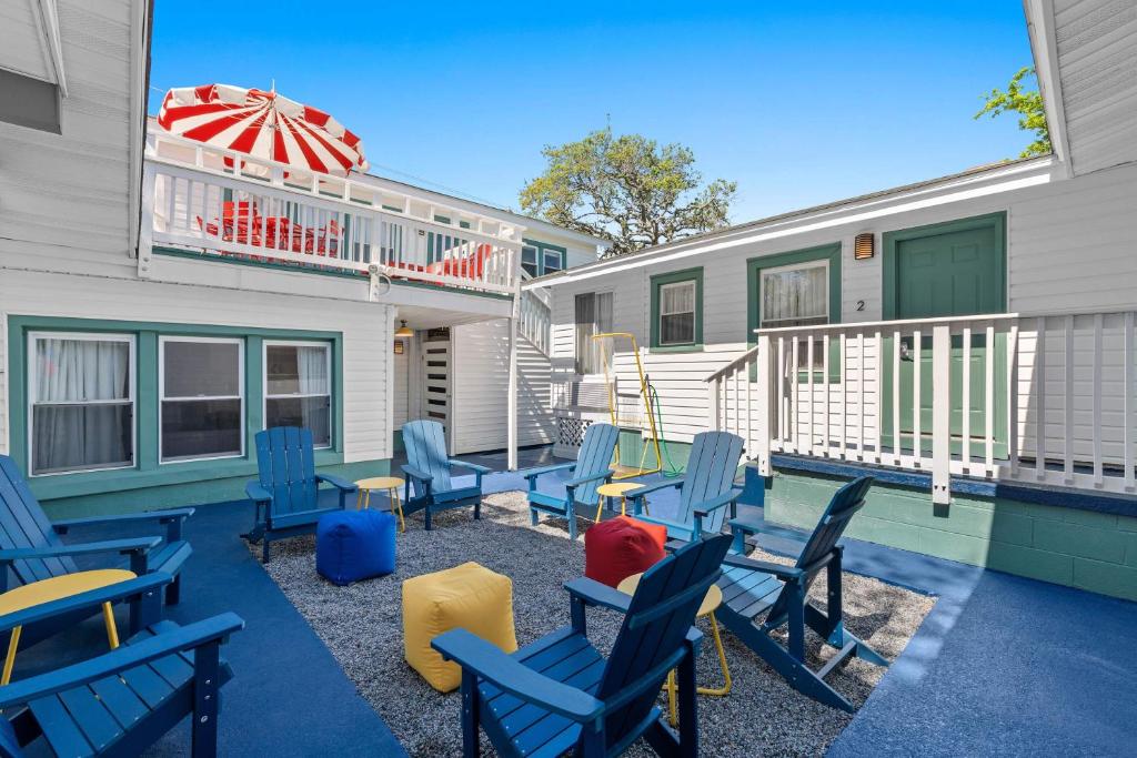 eine Terrasse mit blauen Stühlen und einem Sonnenschirm in der Unterkunft 4BR2BA Sleeps 12 Pet-Friendly Steps to Beach in Myrtle Beach