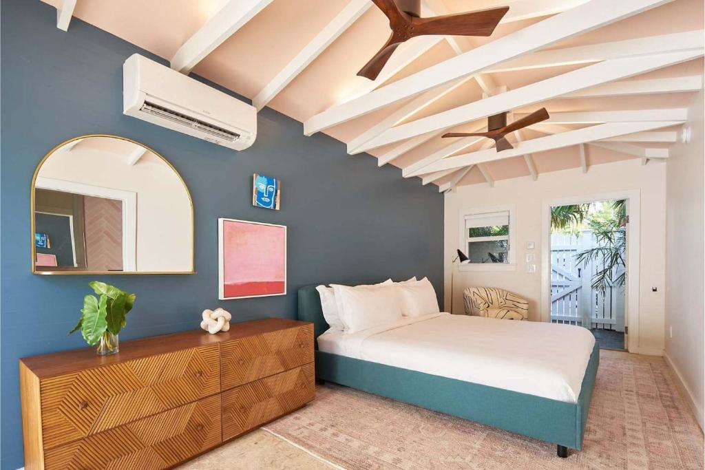 un dormitorio con una cama y un espejo en Carriage House at Grand Maloney, en Key West