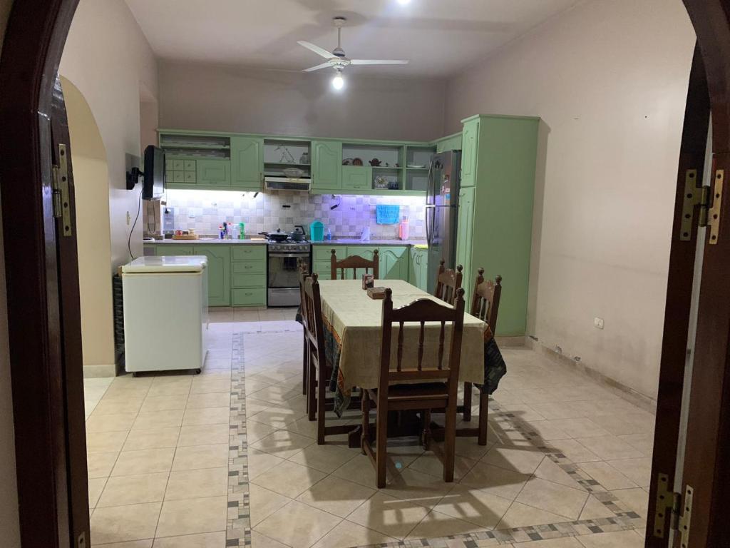 a kitchen with green cabinets and a table and chairs at Casa zona Estadio Único Fórum Terminal de omnibus Peatonales A Minutos del Nodo Tecnológico in Santiago del Estero