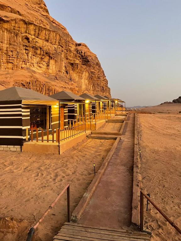 una fila di resort nel deserto accanto a una montagna di North moon Camp a Wadi Rum