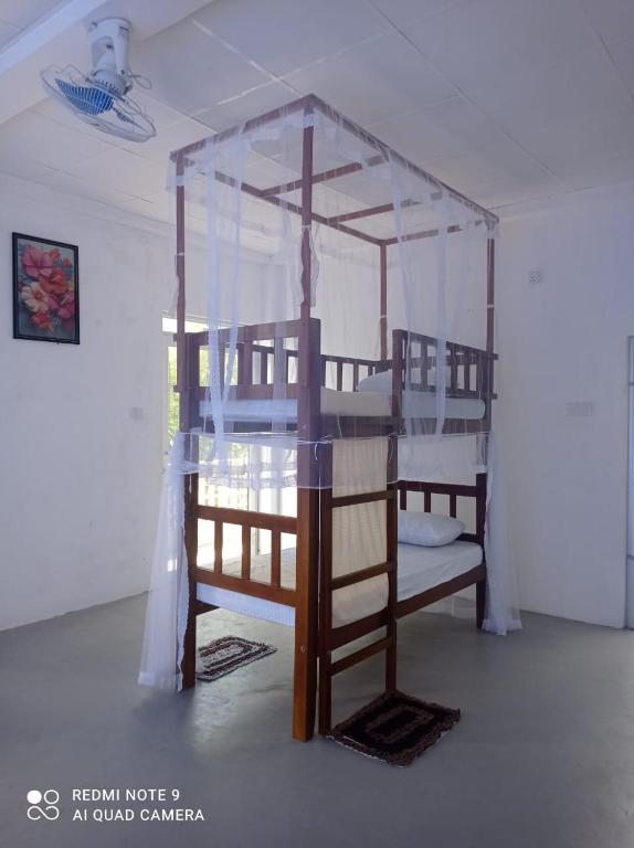 a bunk bed with a canopy in a room at Dream Sun hostel in Weligama