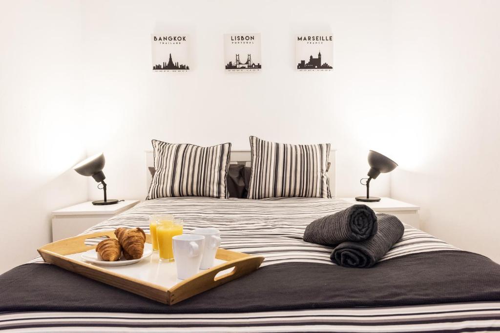 - un lit avec un plateau de pain et du jus d'orange dans l'établissement Luminosos apartamentos con ascensor en el Centro, SOL, à Madrid