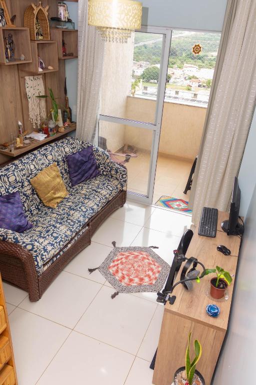 a living room with a couch and a table at Quarto Residencial Dubai - Lazer Completo in Brasília