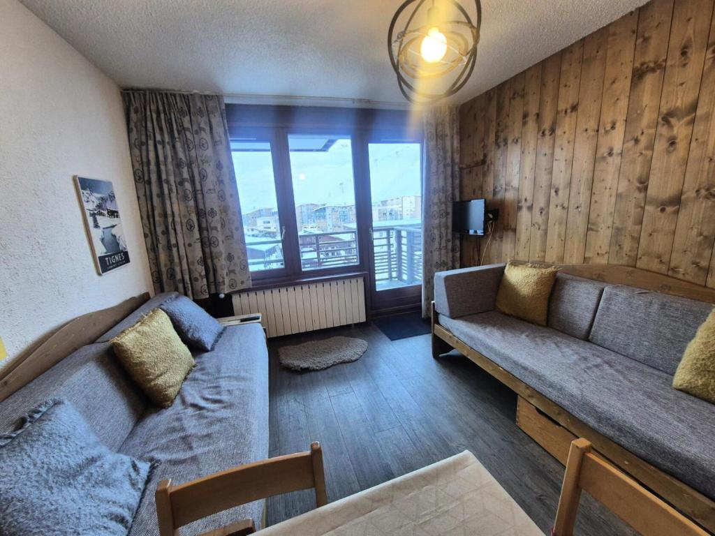 un salon avec un canapé et une grande fenêtre dans l'établissement Résidence Curling B1-b2 - Appartement accueillant et lumineux · MAE-6772, à Tignes