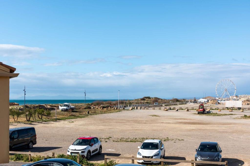 a group of cars parked in a parking lot near the ocean at SP350-188 Appartement 2 pièces cabine SAINT PIERRE LA MER in Saint Pierre La Mer