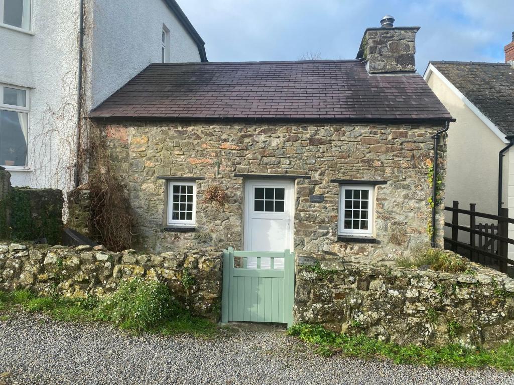an old stone house with a green door at Banc Cottage in Pembrokeshire