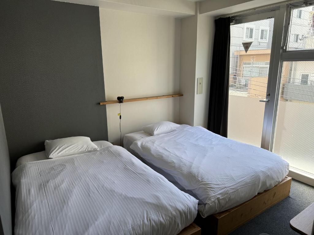 Postel nebo postele na pokoji v ubytování Santiago Guesthouse Hiroshima
