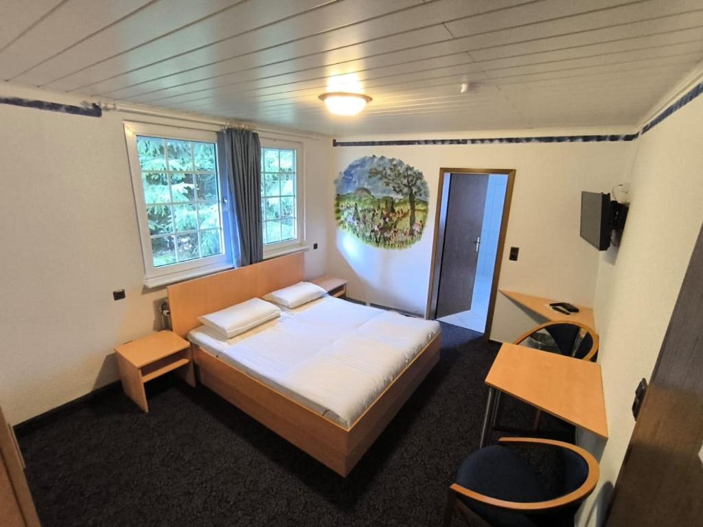 a bedroom with a bed and a desk and two windows at Smart Resorts B&B 3 BB 1003 in Winterberg