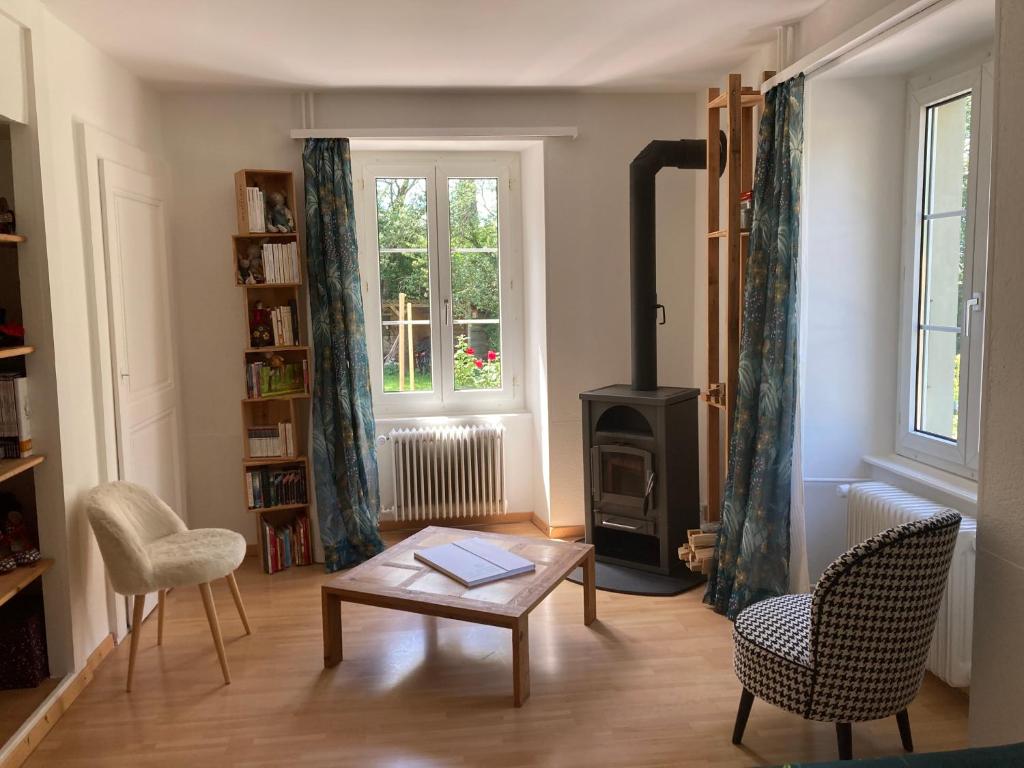 a living room with a table and a wood stove at Logement cosy in Saint-Legier-La Chiesaz