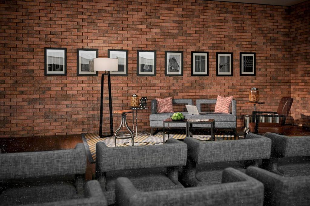 A cosy brick-walled lounge with framed art, sofas and a small round table.
