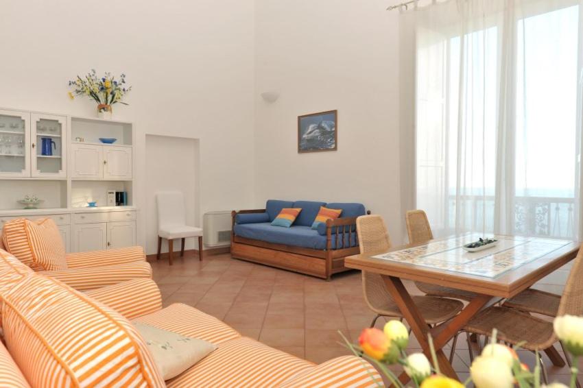 un soggiorno con divano blu e tavolo di La Risacca - Ravello Accommodation a Minori