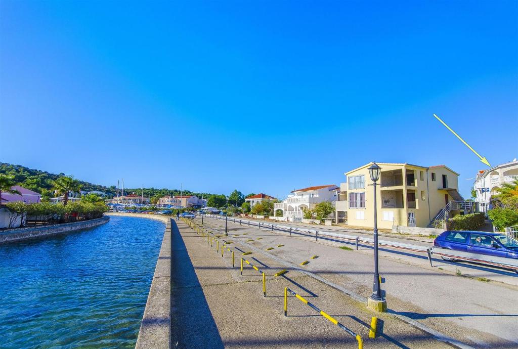 a canal with houses and buildings next to the water at Apartments Perisa in Rogoznica