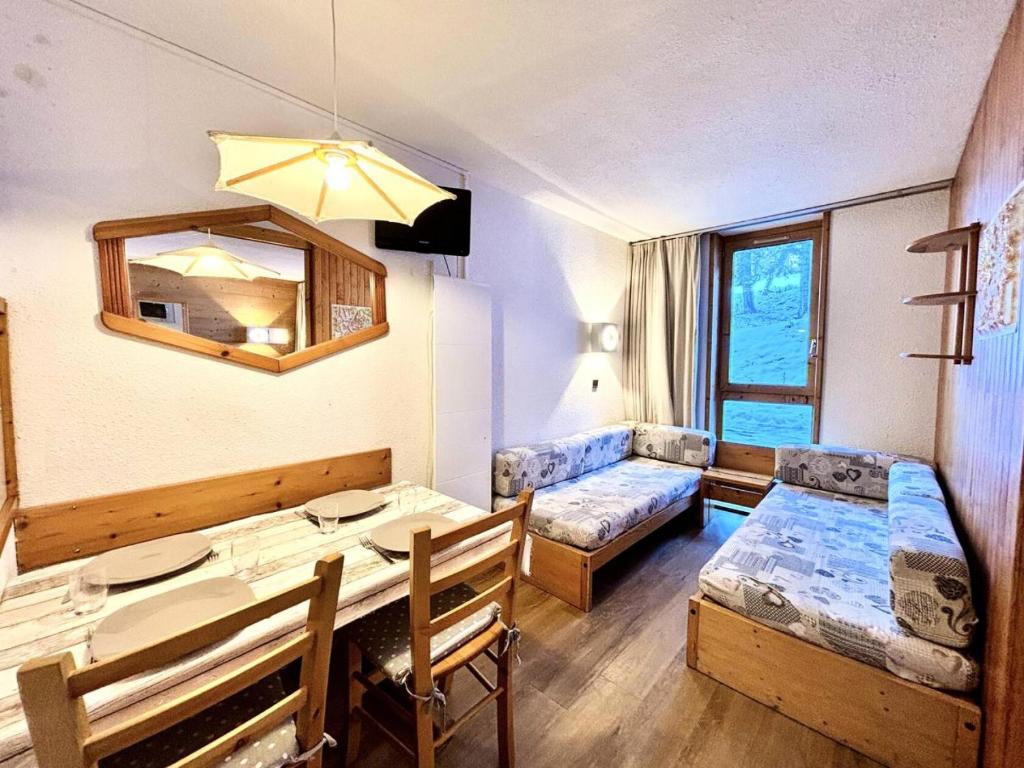 Cette petite chambre comprend une table et un canapé. dans l'établissement Résidence Le Zig Zag - ZIG ZAG 01 MAE-0391, à La Plagne Tarentaise