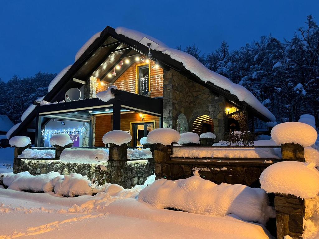 a house covered in snow at night at Liko Diko Holiday Home in Gospić